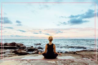 A woman meditating on a beach