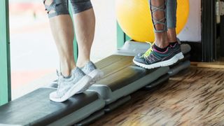 Women doing calf raises on block in the gym