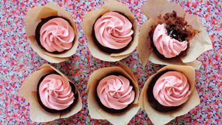Six chocolate and jam cupcakes with a pink buttercream