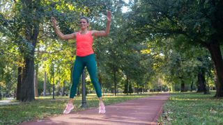 Woman doing jumping jacks in park