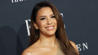 Image of Eva Longoria smiling with long straight brunette hair and wearing a crystal-embellished one-shoulder dress