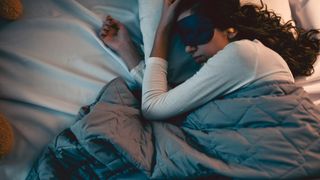 woman asleep under weighted blanket