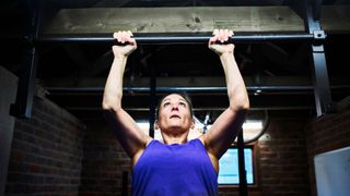 Woman doing pull up exercise in home gym