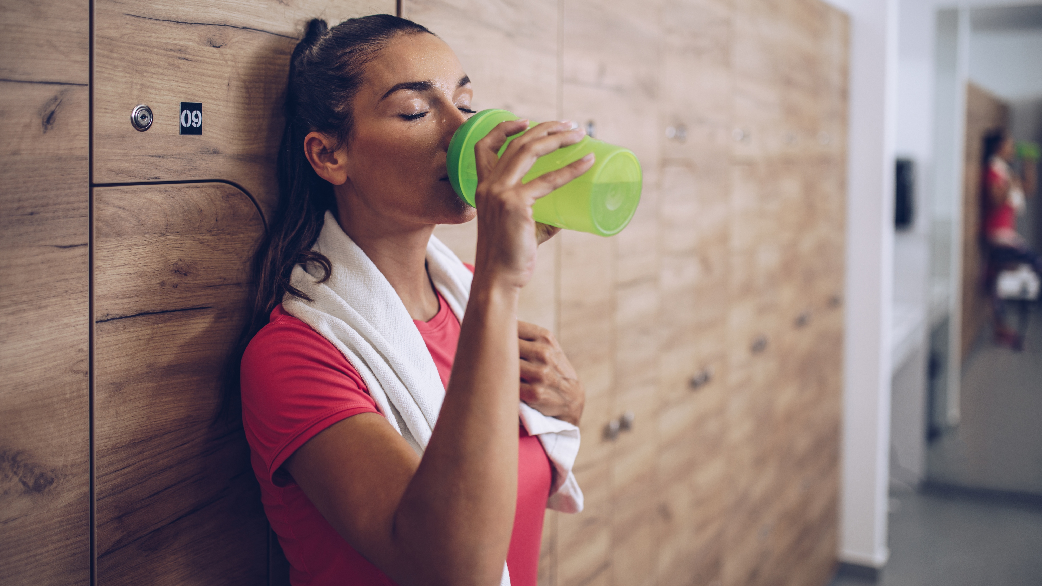 woman drinking electrolytes at the gym