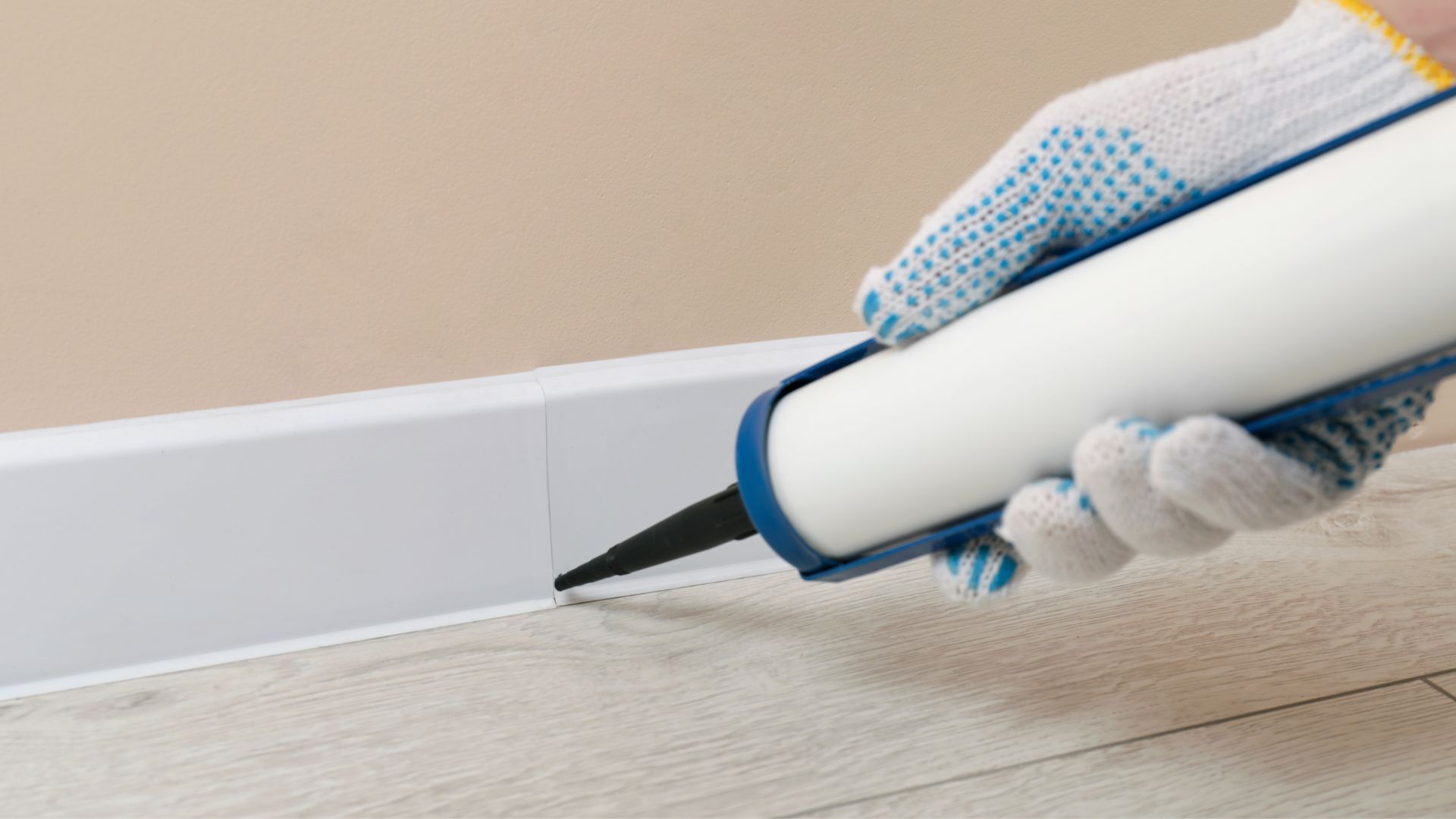 picture of person caulking gaps in skirting board