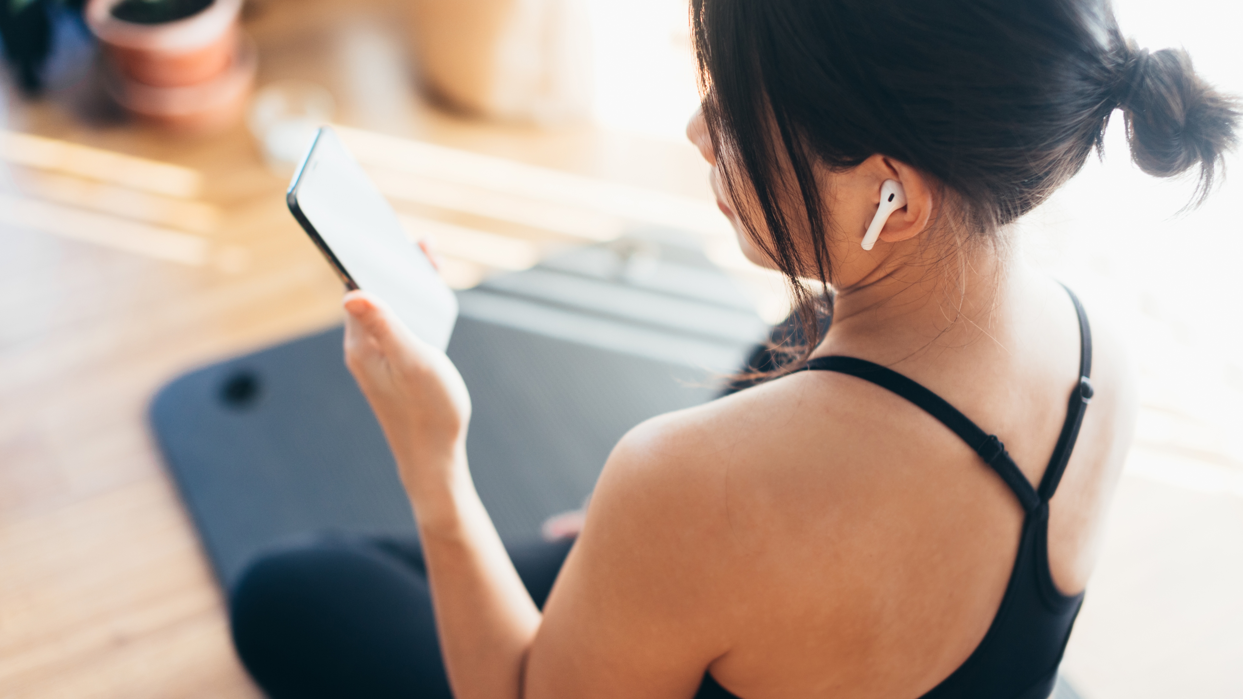 woman using wireless earphones at gym