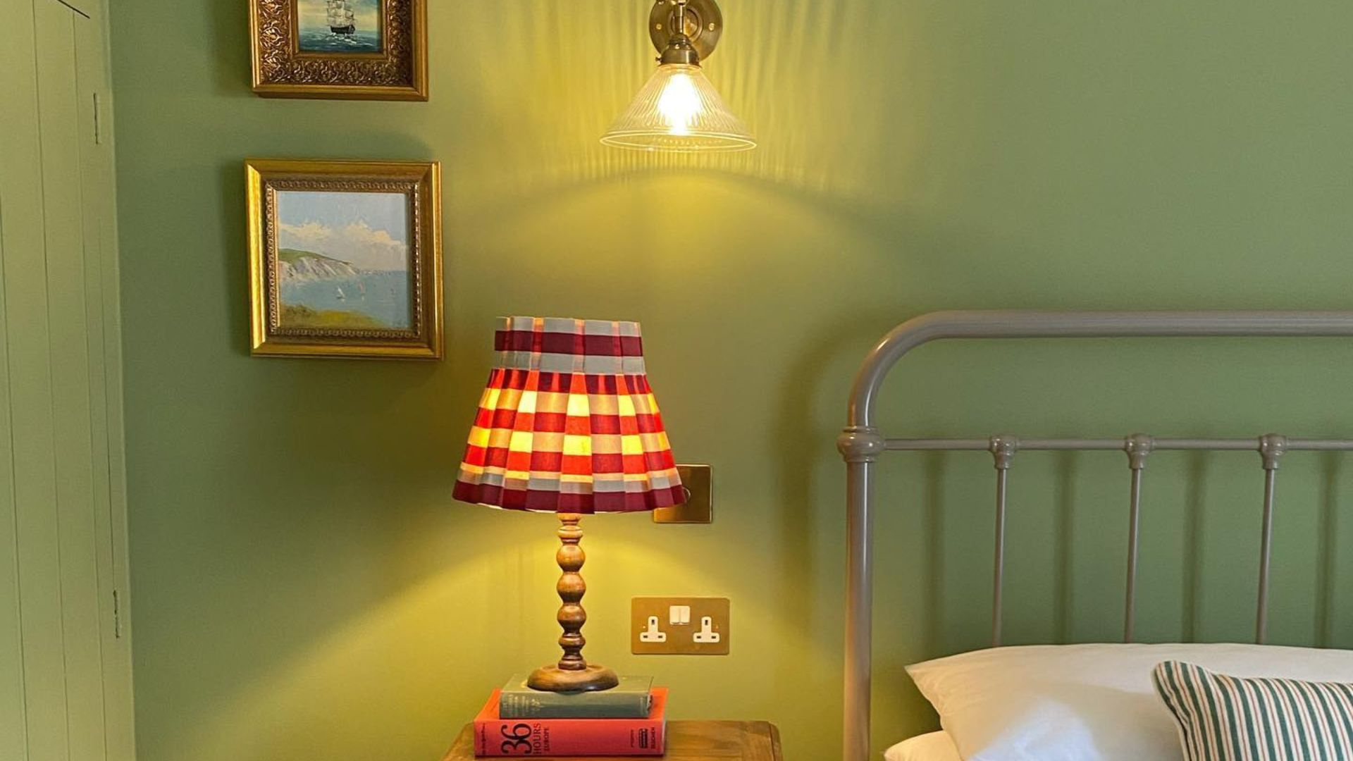 A bedroom with a brass bed painted in pistachio green paint