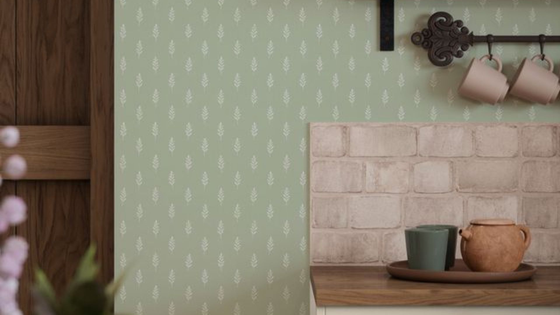 A close up of a kitchen with a pistachio green feature wall