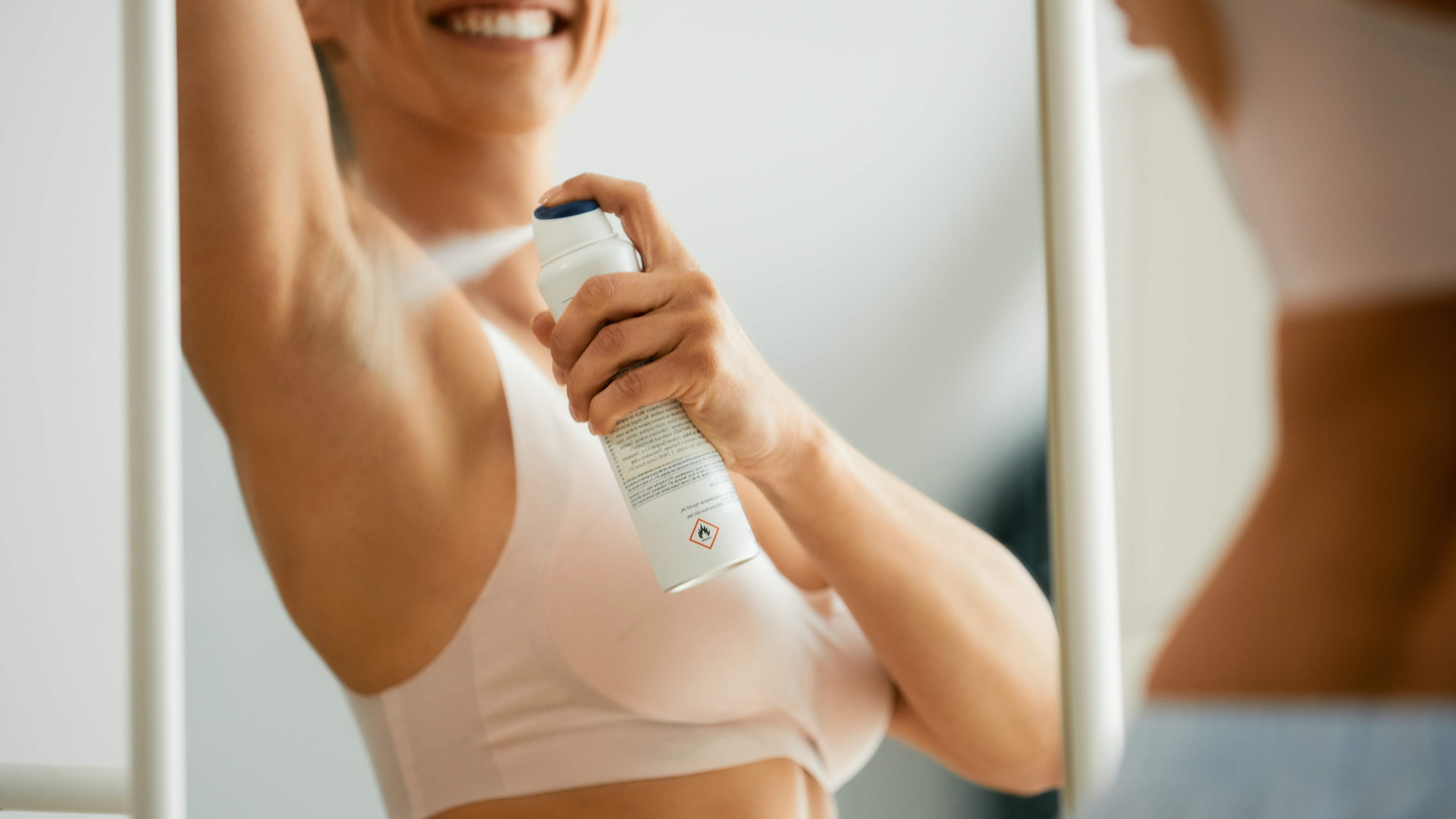 woman spraying deodorant