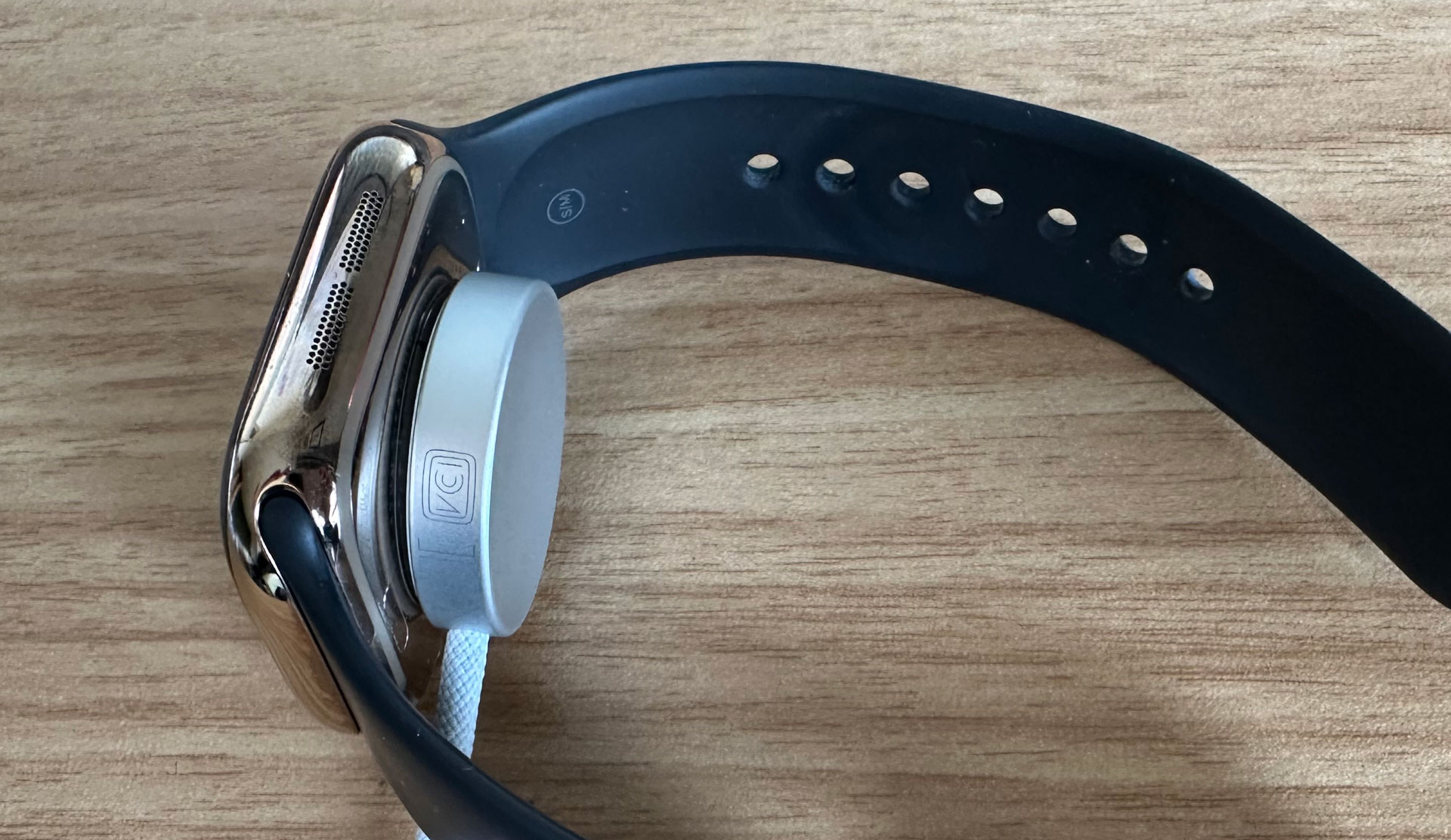 Apple Watch Series 10 on it's side with charger attached to the back