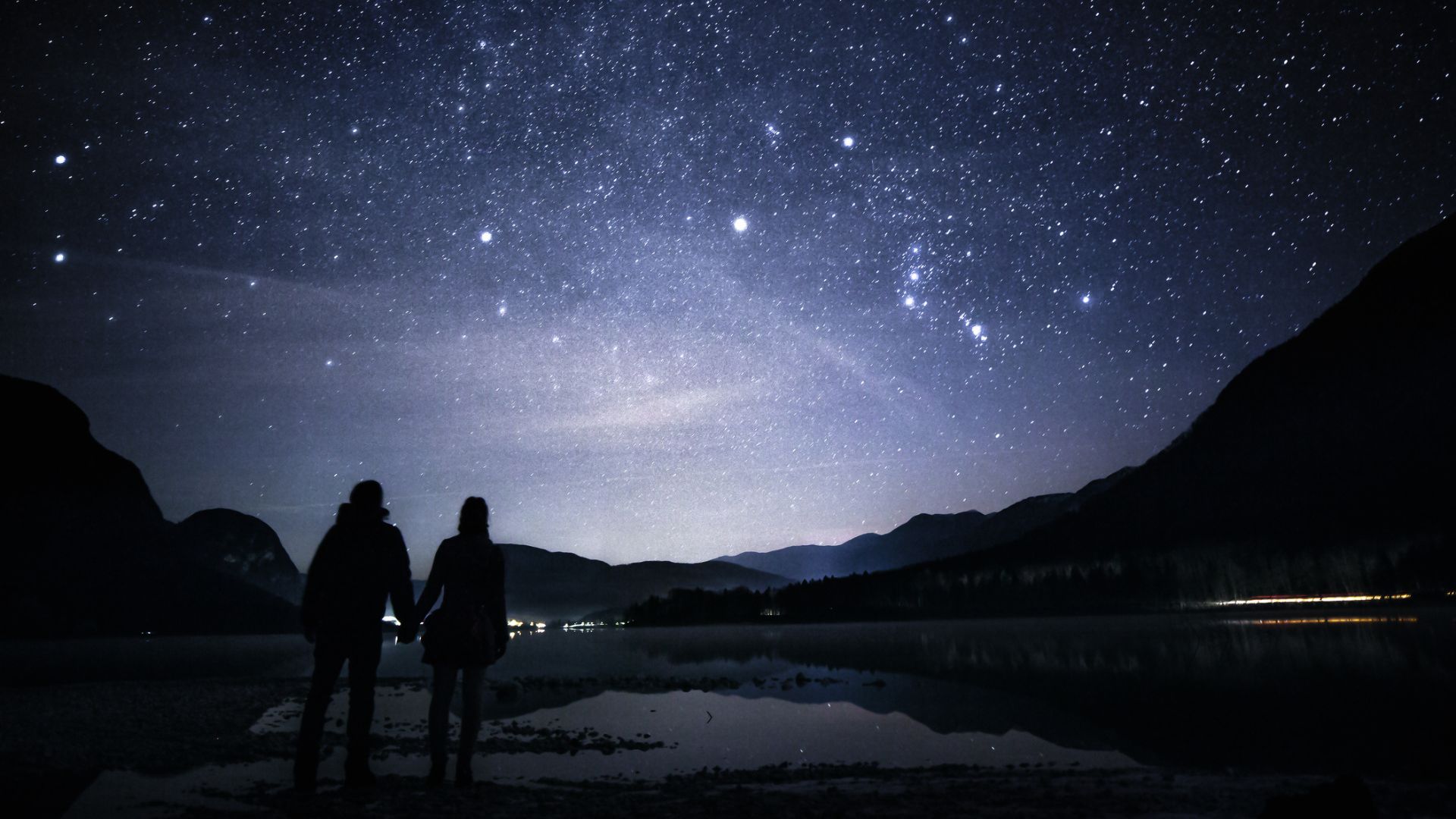 A couple stargaze at a lake