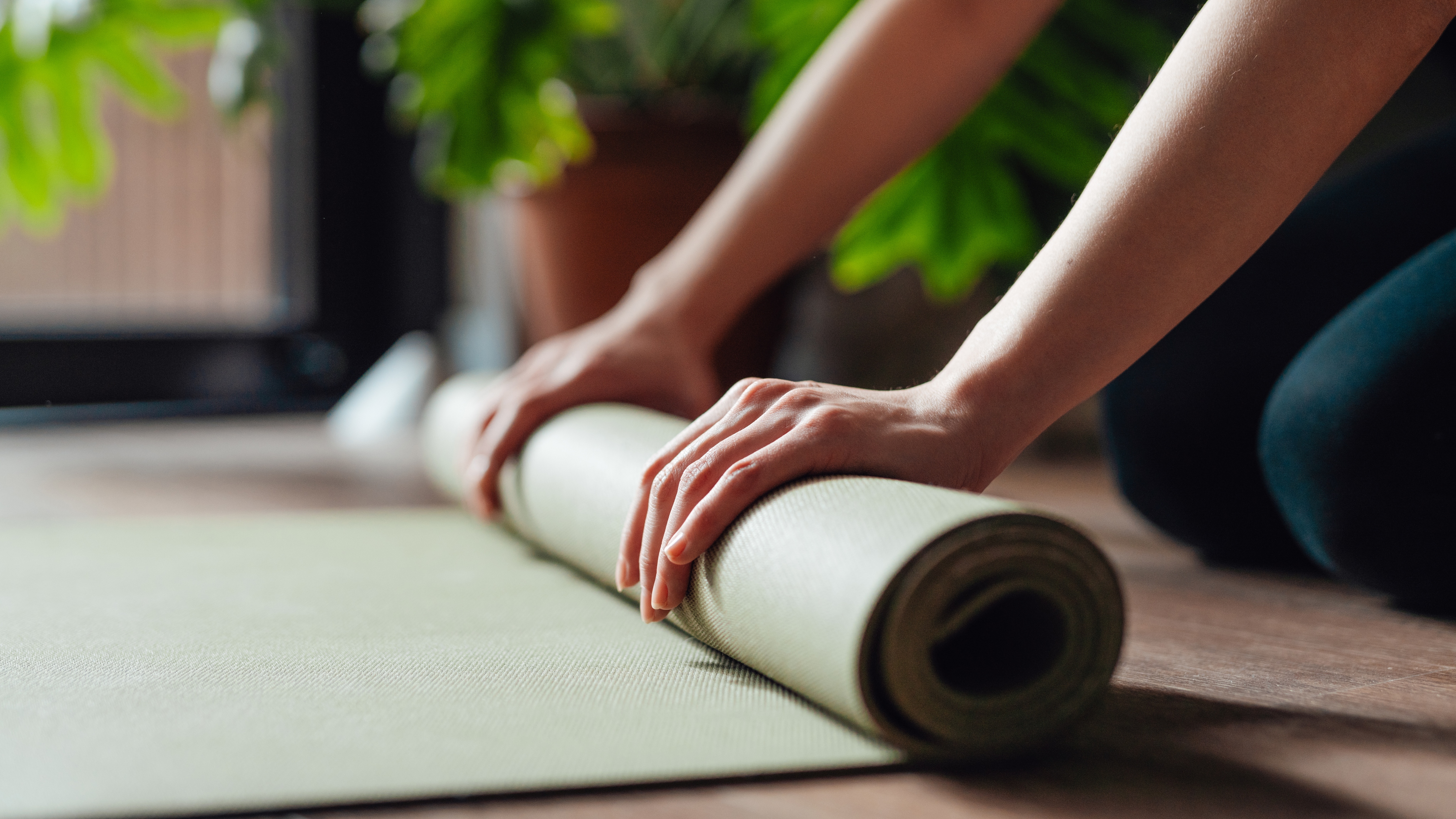 woman rolling up yoga mat