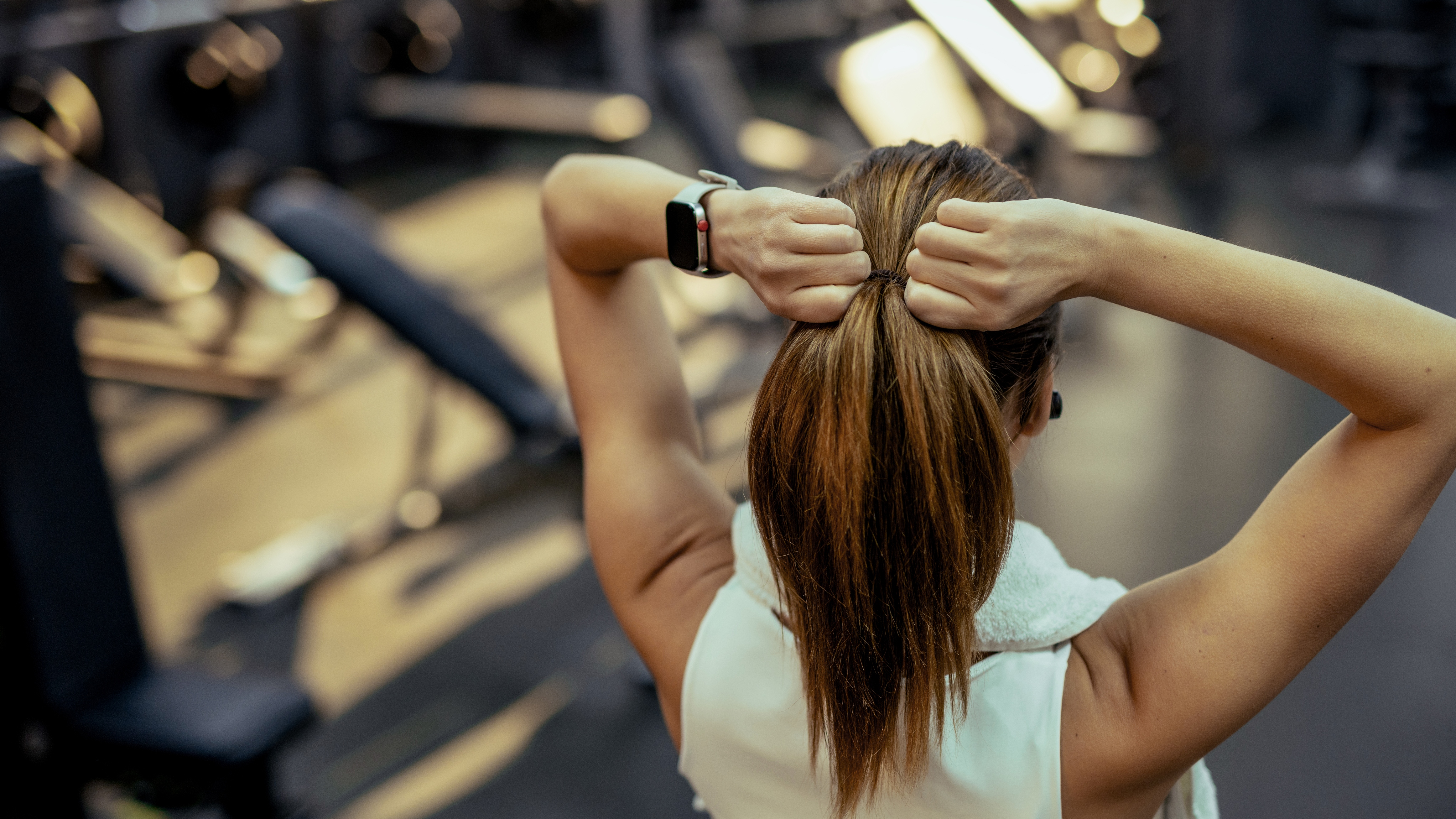 woman tying hair in gym