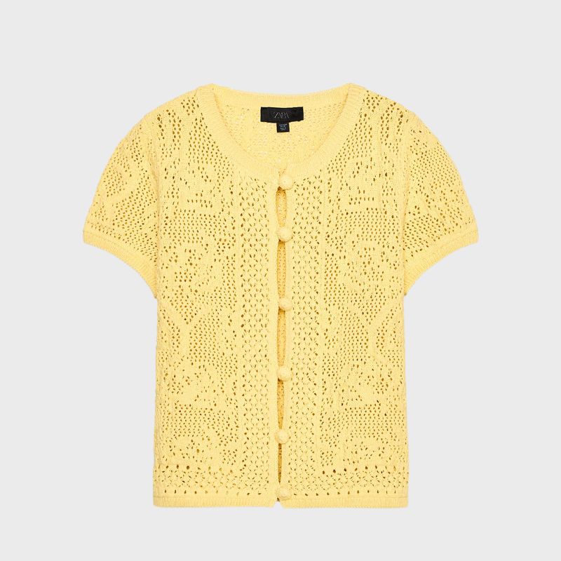 A cutout of a yellow crochet cardigan by Zara