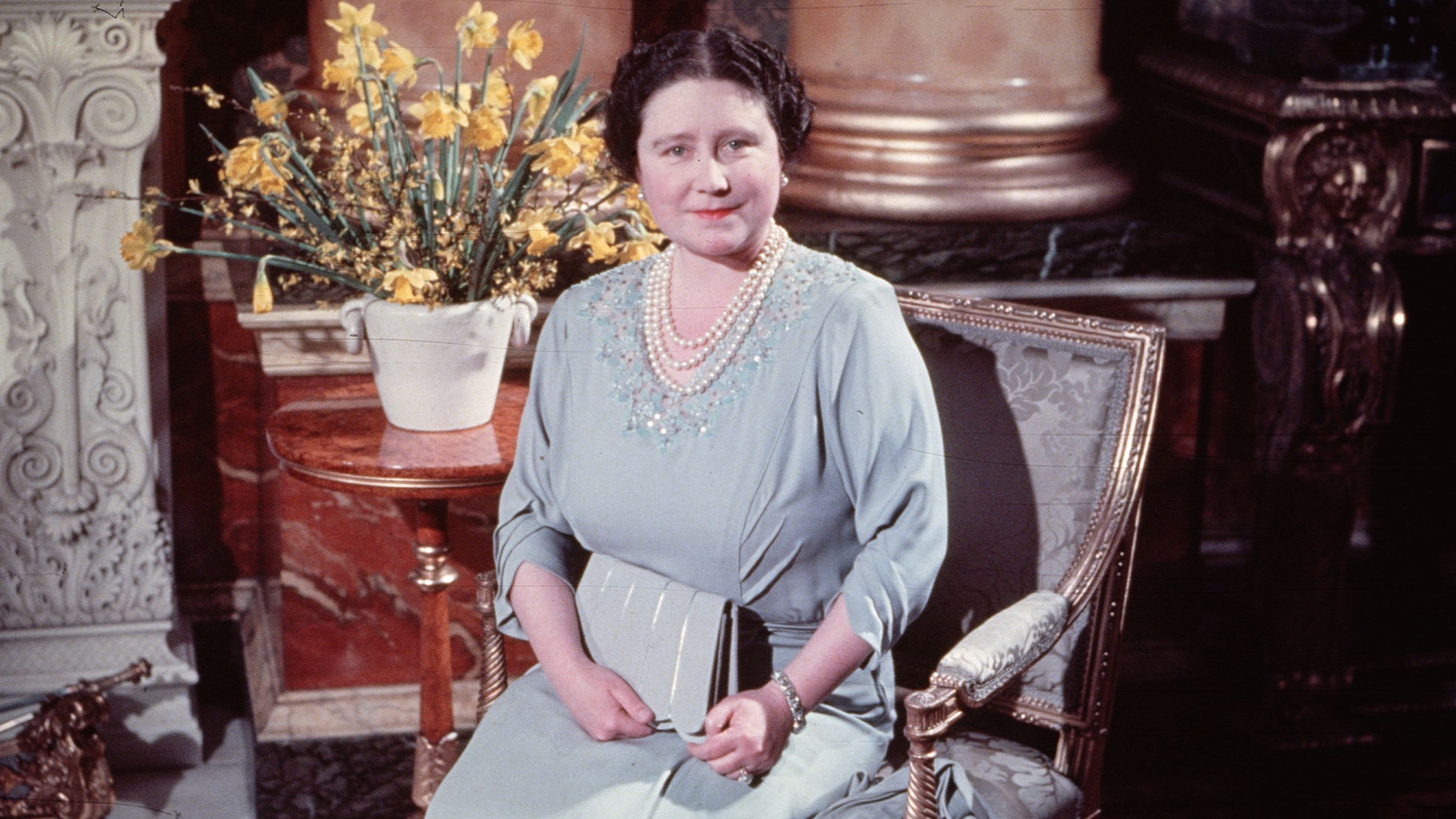 Queen Elizabeth sitting at Buckingham Palace