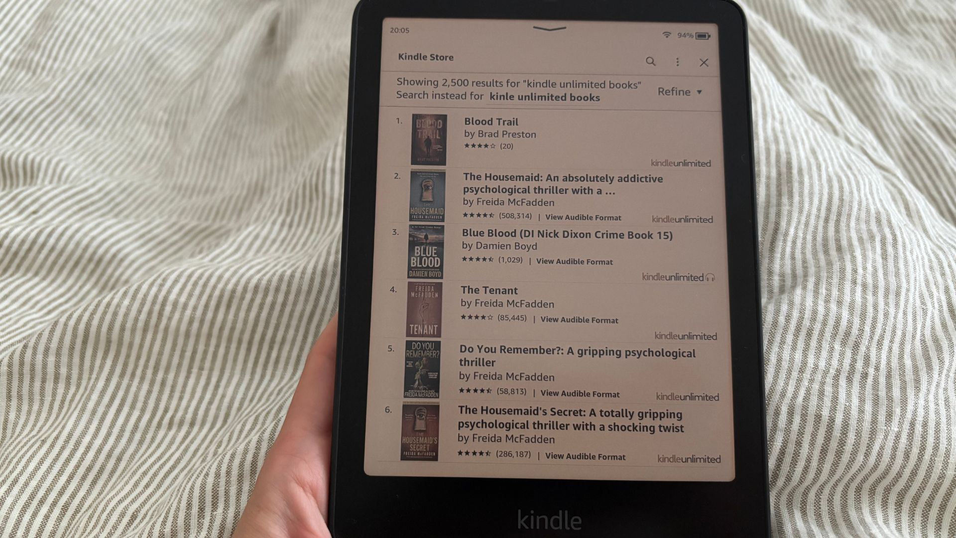 The Kindle Colorsoft with Kindle Unlimited open on my bed