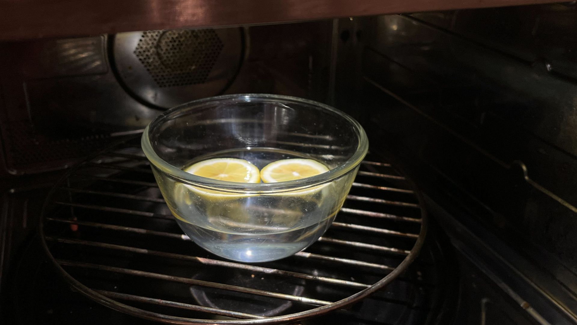 picture of glass bowl with lemon slices and water in microwave