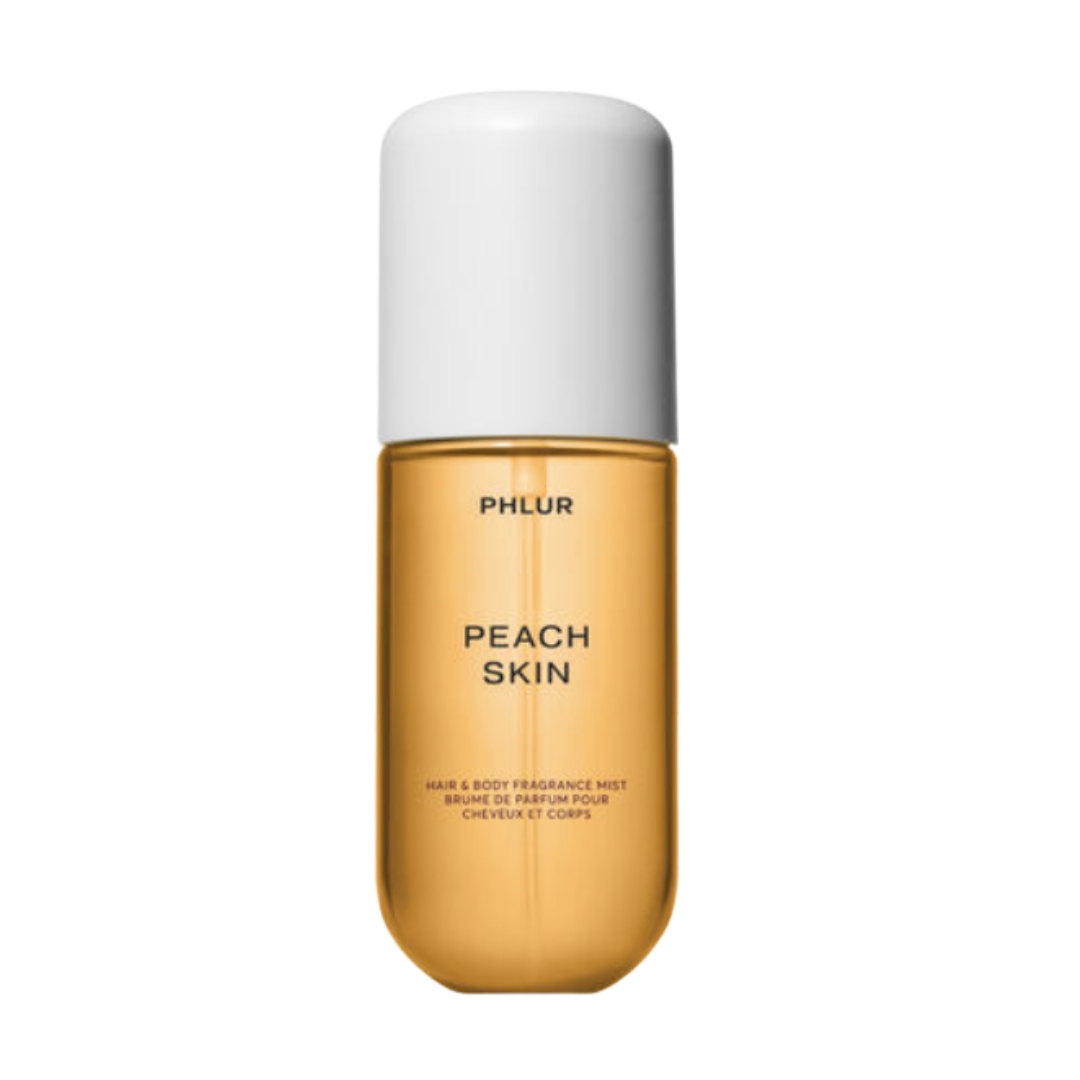 A product shot of the PHLUR peach skin body mist, which features an orange bottle, on a white background