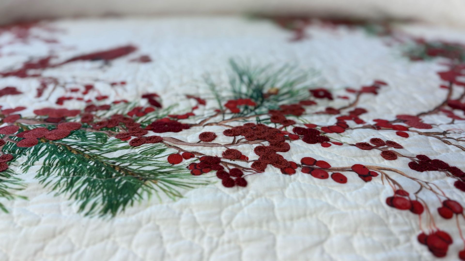 picture of bedspread with red berries and fir branches