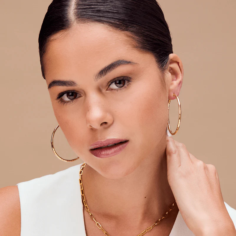 A woman wearing large gold hoop earrings