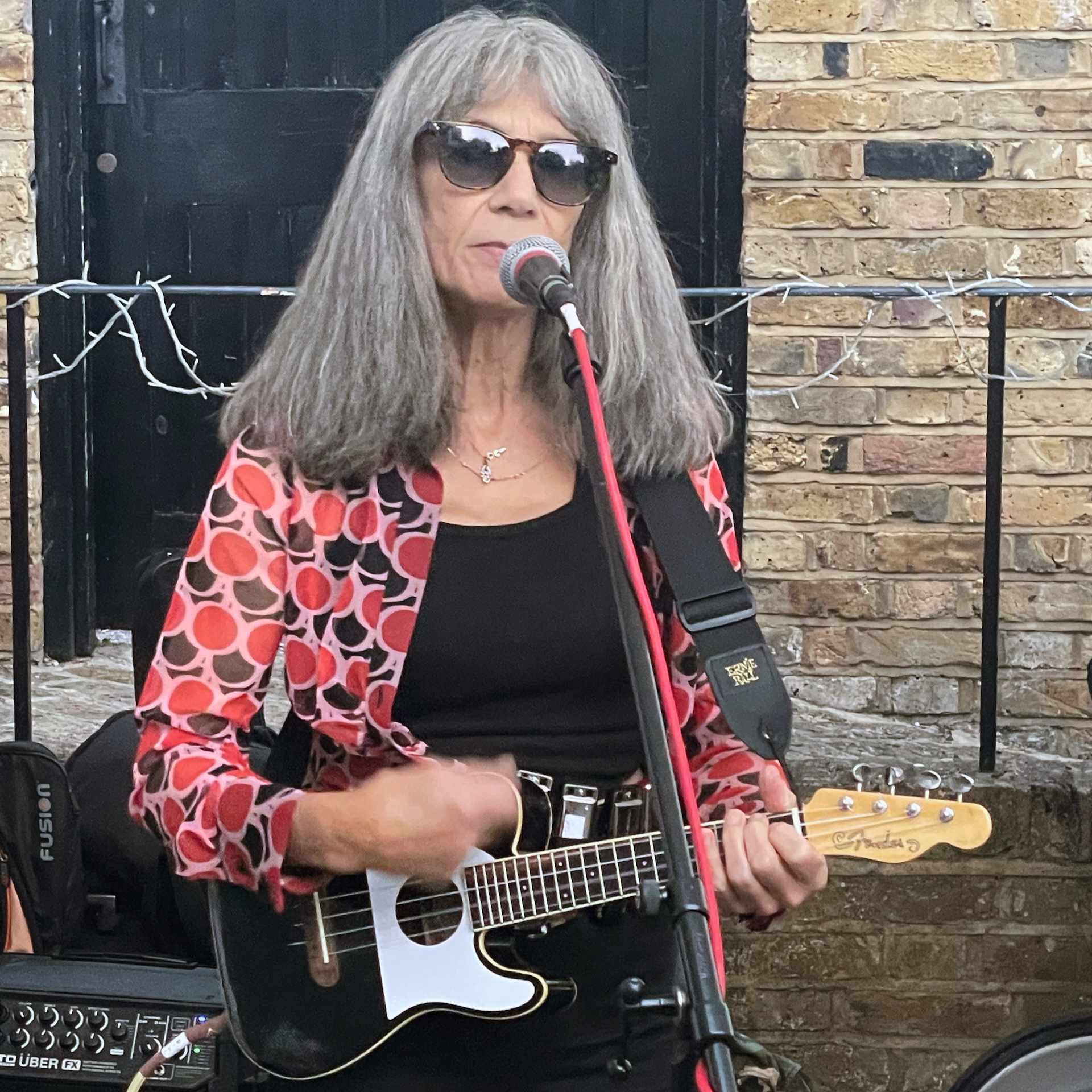Gill Abela from Ukadelix playing an electric guitar and singing into a microphone