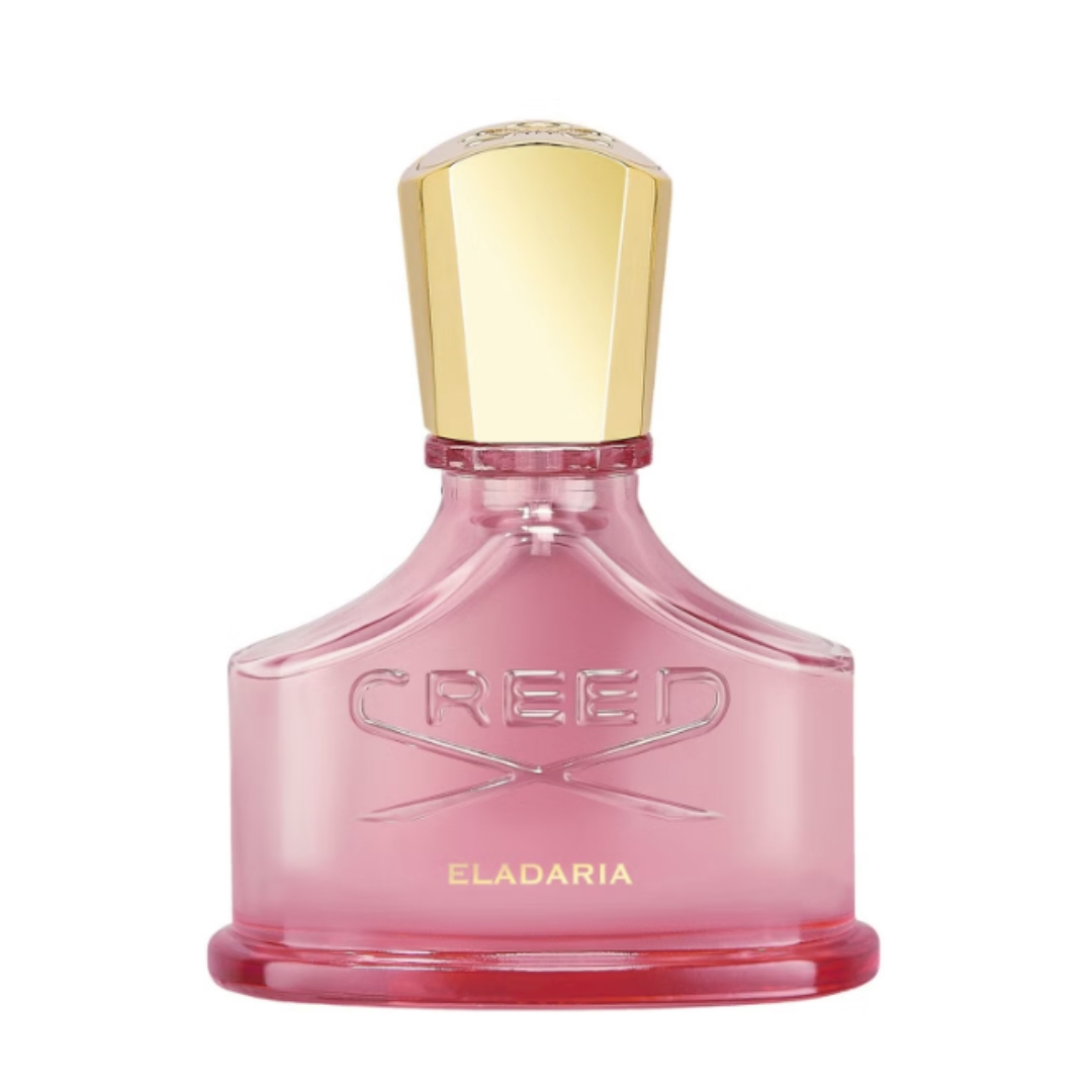 A product shot of the Creed Eladaria perfume, which features a pink bottle and gold lid, on a white background