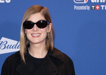 Rosamund Pike uses a contrast handbag to brighten her look