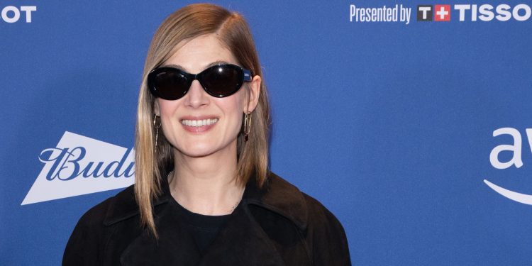 Rosamund Pike uses a contrast handbag to brighten her look