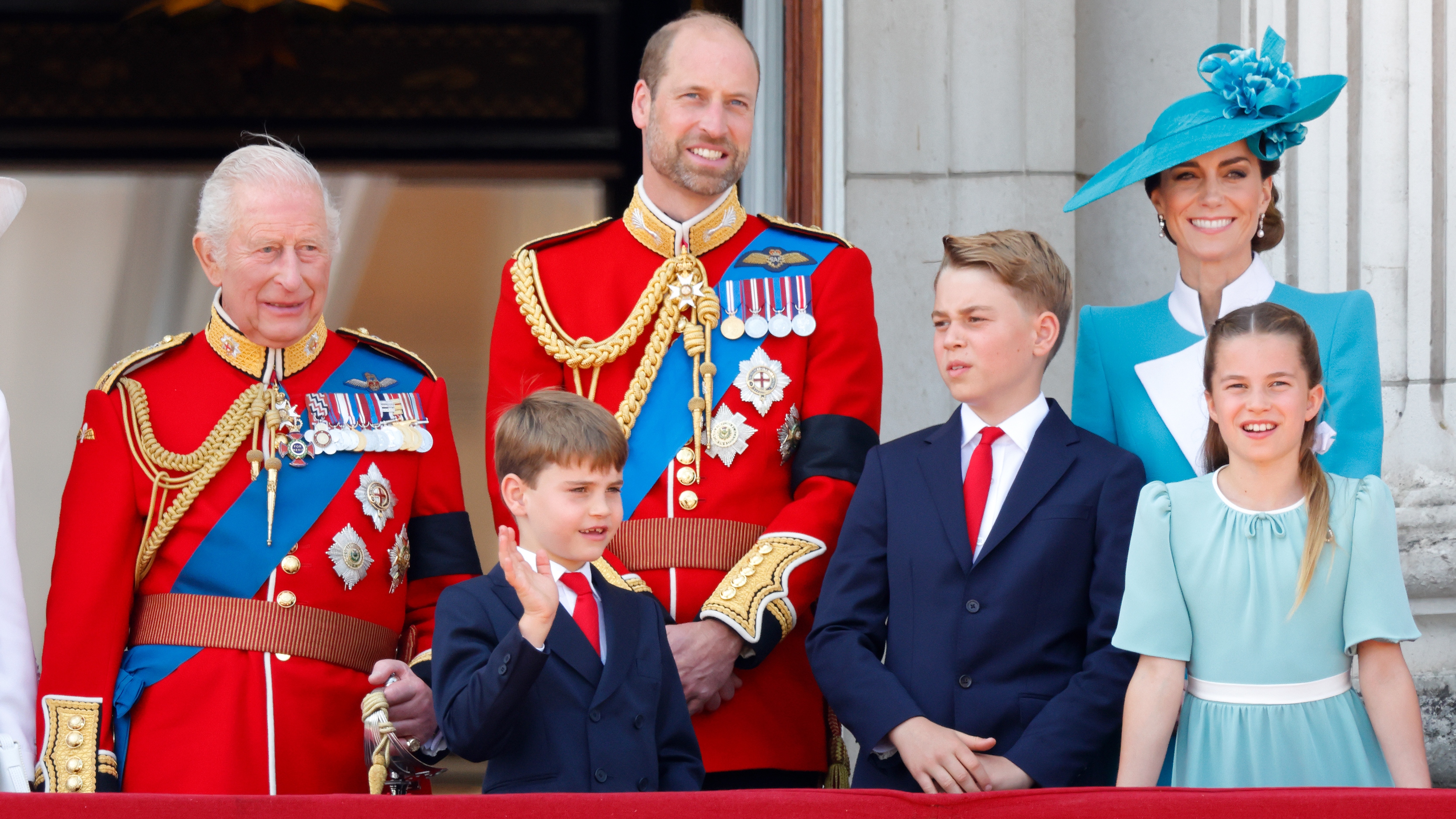 King Charles III (wearing his Coldstream Guards uniform), Prince Louis of Wales, Prince William (Colonel of the Welsh Guards), Prince George of Wales, Catherine, Princess of Wales and Princess Charlotte of Wales watch an RAF flypast from the balcony of Buckingham Palace